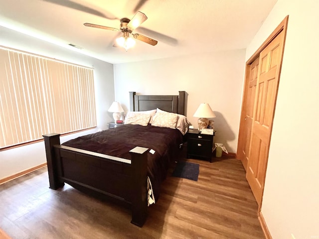 bedroom with baseboards, ceiling fan, wood finished floors, and visible vents