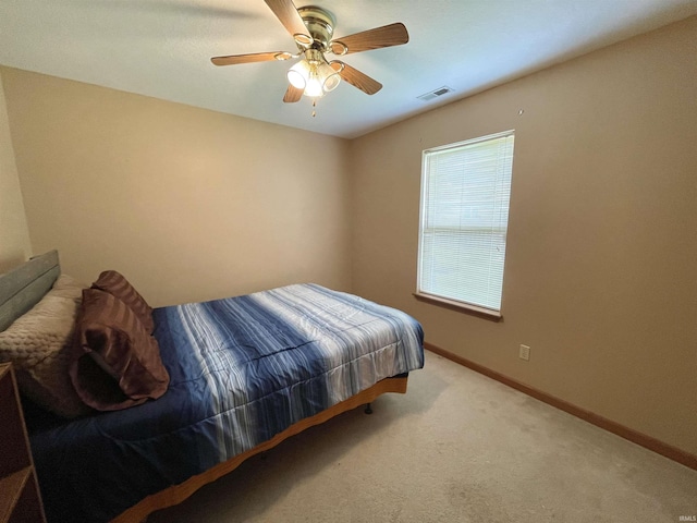 bedroom with baseboards, visible vents, ceiling fan, and carpet