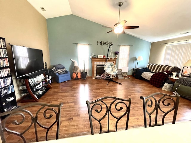 living room featuring visible vents, ceiling fan, lofted ceiling, and wood finished floors