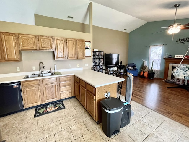 kitchen featuring vaulted ceiling, dishwasher, a sink, light countertops, and open floor plan