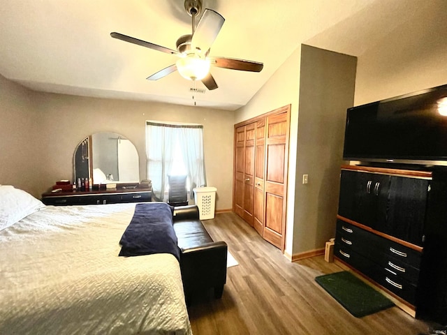 bedroom with light wood-style floors, a ceiling fan, baseboards, vaulted ceiling, and a closet