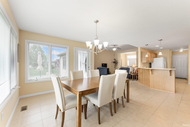 dining area featuring an inviting chandelier, baseboards, light tile patterned floors, and visible vents