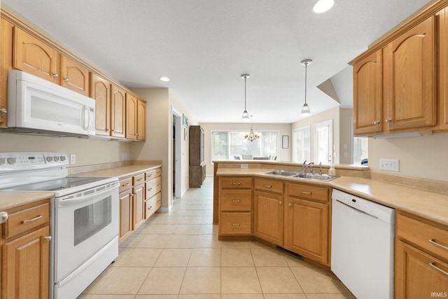 kitchen featuring decorative light fixtures, a sink, light countertops, recessed lighting, and white appliances