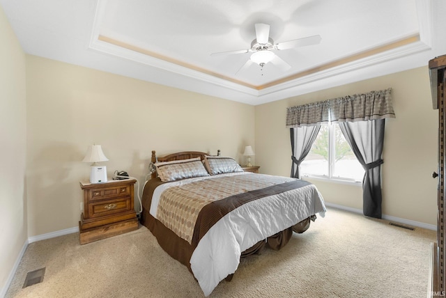 bedroom with carpet flooring, baseboards, visible vents, and a raised ceiling
