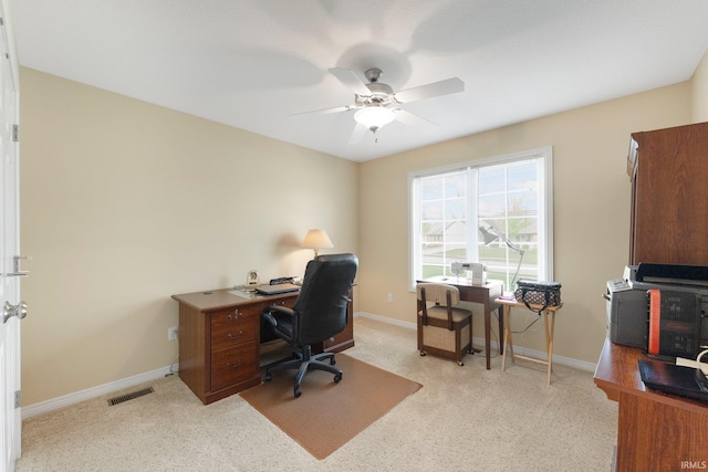home office featuring baseboards, ceiling fan, and light colored carpet