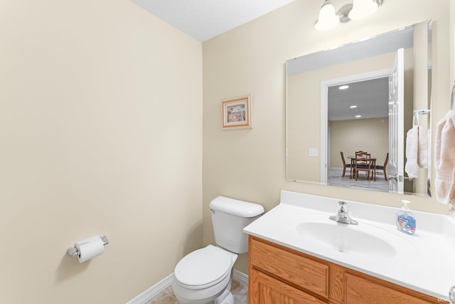 bathroom with vanity, baseboards, and toilet