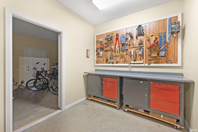 bar featuring baseboards, indoor bar, and concrete floors