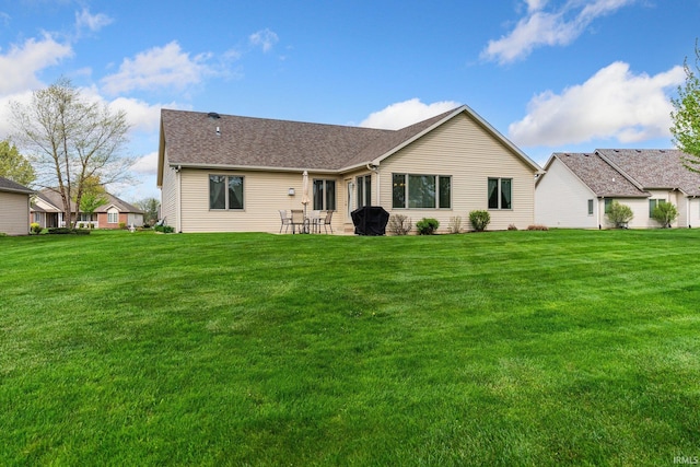 rear view of house featuring a yard and a patio area