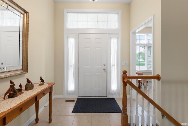 foyer entrance with light tile patterned floors, baseboards, and visible vents