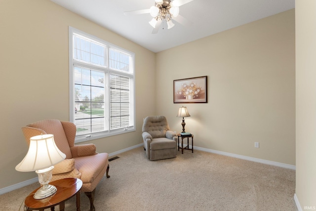 living area featuring a ceiling fan, baseboards, visible vents, and carpet
