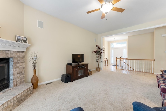 living area with carpet floors, baseboards, visible vents, and a fireplace