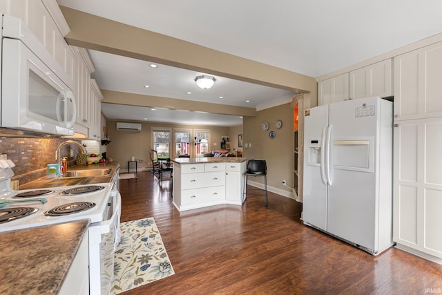 kitchen featuring white appliances, a wall mounted air conditioner, dark wood-style floors, tasteful backsplash, and a sink