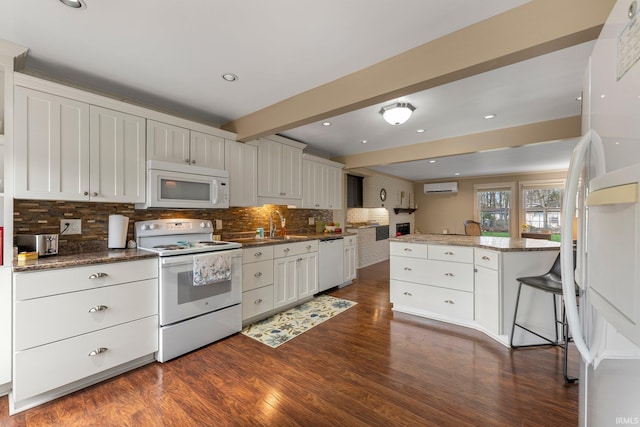 kitchen with backsplash, a wall mounted AC, dark wood-style floors, and white appliances