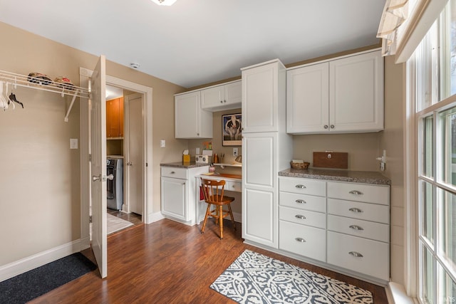 kitchen featuring baseboards, stove, dark wood-style flooring, and white cabinetry