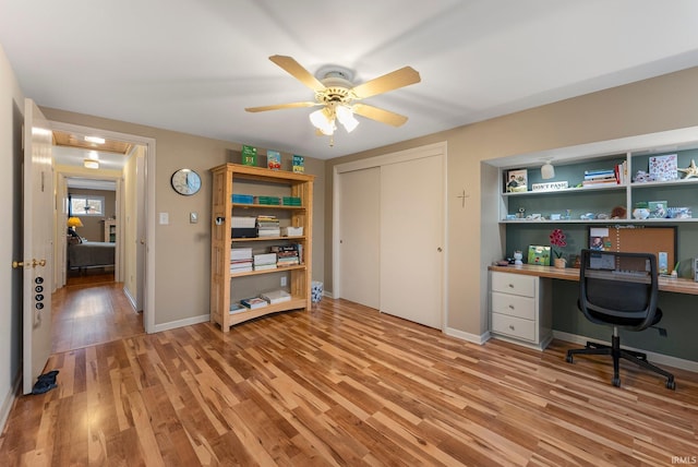 office area featuring baseboards, ceiling fan, and light wood-style flooring