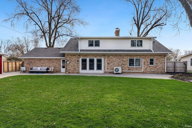 rear view of house with a chimney, brick siding, a patio area, and an outdoor hangout area