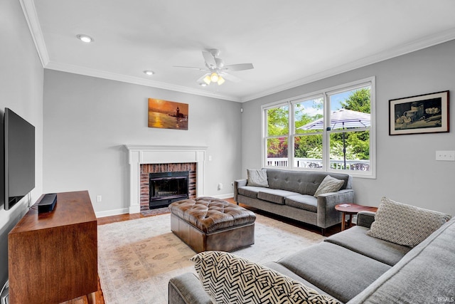 living area featuring baseboards, ornamental molding, a ceiling fan, and light wood-style flooring