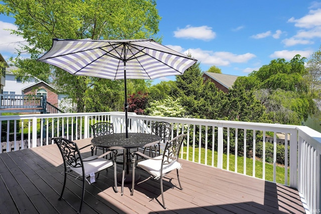 wooden deck with a lawn and outdoor dining space