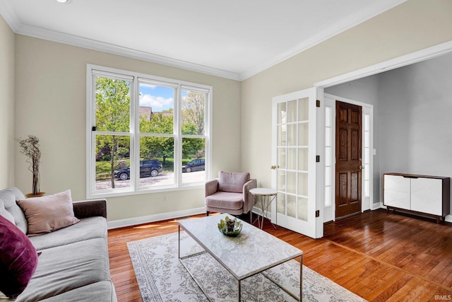 living area with crown molding, baseboards, and wood finished floors