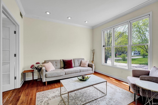living room with recessed lighting, baseboards, ornamental molding, and wood finished floors