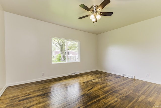 spare room featuring dark wood-style flooring, baseboards, and visible vents