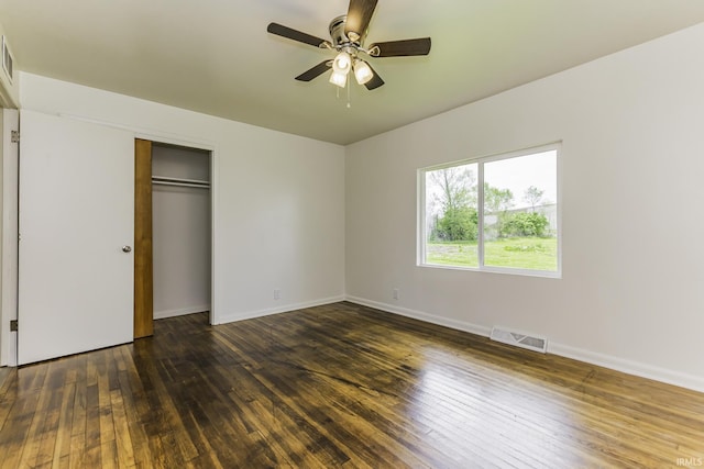 unfurnished bedroom with ceiling fan, visible vents, baseboards, a closet, and hardwood / wood-style floors