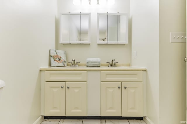bathroom with a sink, baseboards, and double vanity