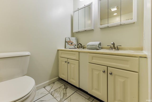 bathroom with baseboards, vanity, toilet, and marble finish floor