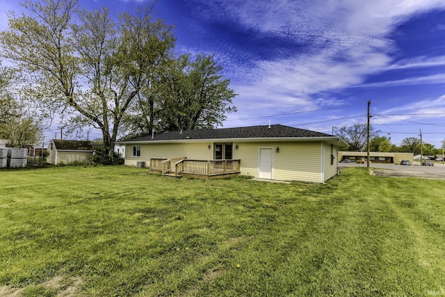 rear view of house with a lawn and a deck