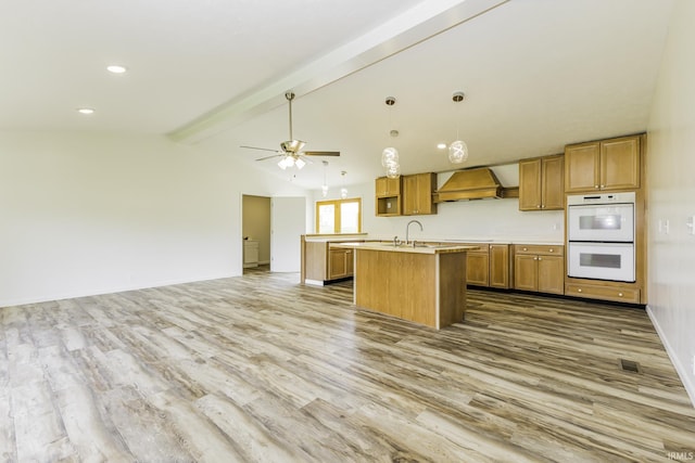 kitchen featuring wood finished floors, light countertops, double oven, open floor plan, and vaulted ceiling with beams