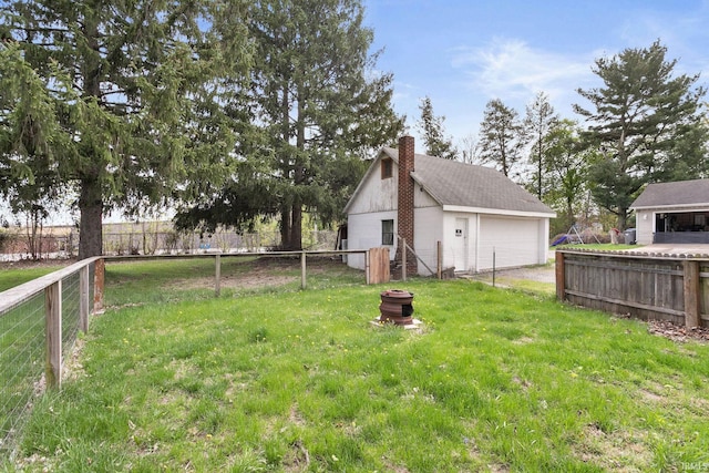 view of yard with an outdoor structure, a garage, and fence