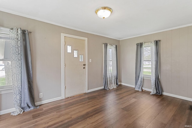 foyer entrance featuring crown molding, baseboards, and wood finished floors