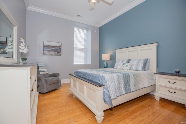 bedroom featuring visible vents, ornamental molding, light wood-style flooring, and ceiling fan