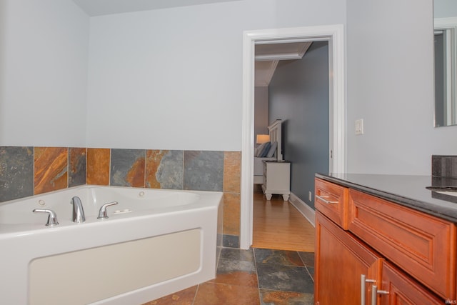 full bath featuring a garden tub, stone finish flooring, and vanity