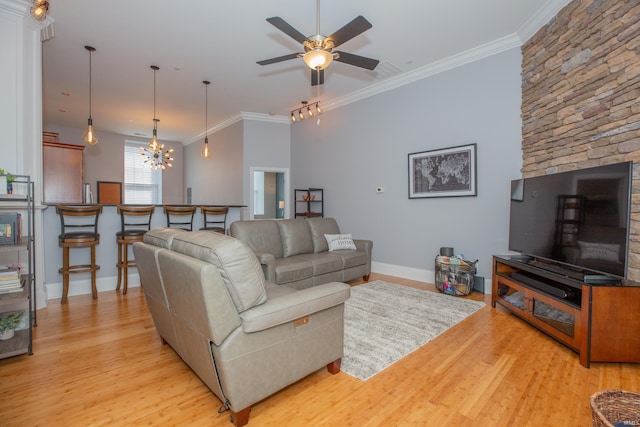 living room featuring crown molding, baseboards, ceiling fan with notable chandelier, and light wood-style floors