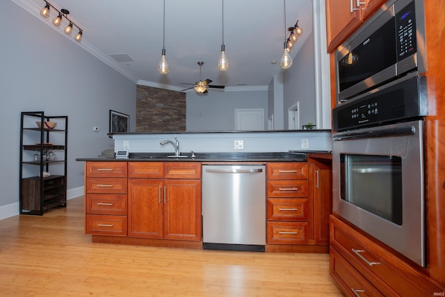 kitchen featuring visible vents, ornamental molding, ceiling fan, a sink, and stainless steel appliances