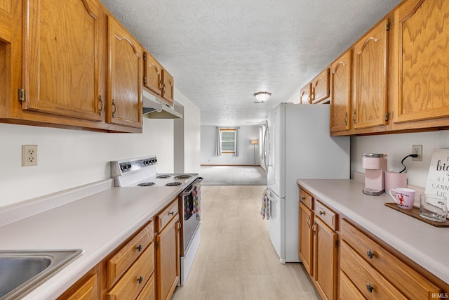 kitchen with white appliances, a textured ceiling, under cabinet range hood, and light countertops