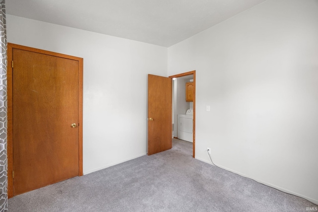 unfurnished bedroom with carpet floors and washer / dryer