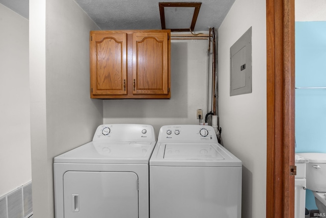 laundry room featuring visible vents, cabinet space, electric panel, and washer and dryer