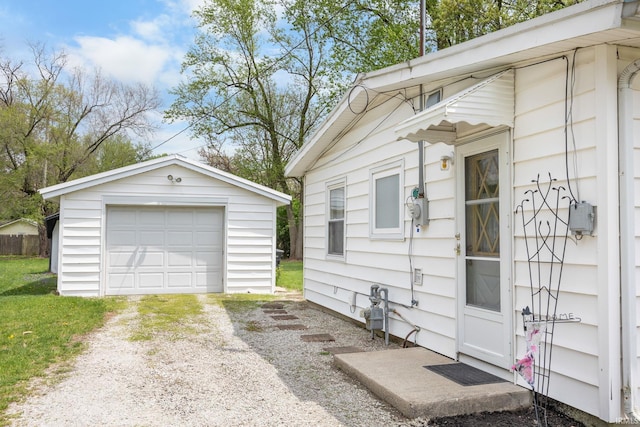 view of home's exterior featuring a garage, dirt driveway, and an outdoor structure