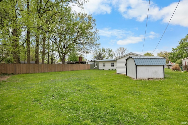view of yard with fence, an outbuilding, and a storage unit