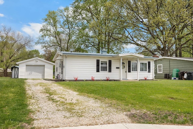 view of front of home featuring a detached garage, dirt driveway, an outdoor structure, and a front lawn