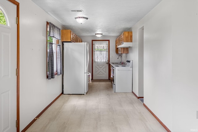 kitchen with a sink, a wealth of natural light, and white appliances