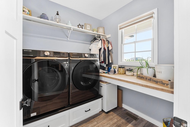laundry room with laundry area, wood finished floors, separate washer and dryer, and visible vents