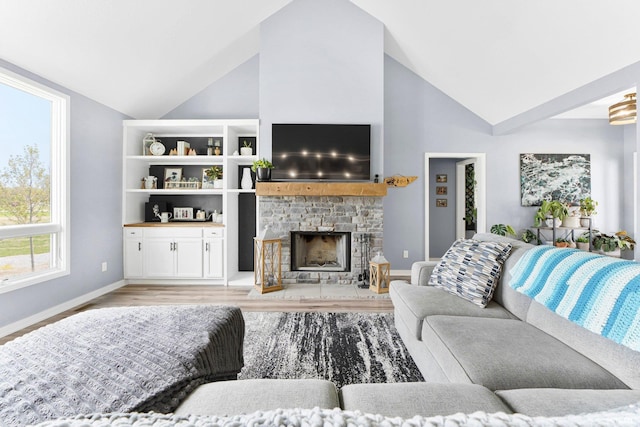living room featuring baseboards, light wood-style flooring, high vaulted ceiling, and a fireplace