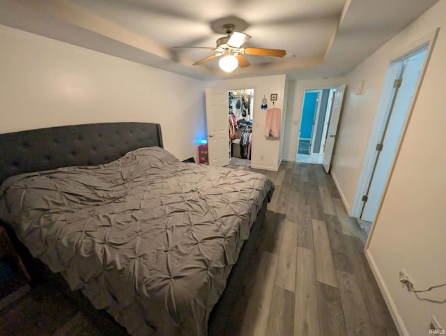 4090 Pinehurst Dr, Jasper, IN 47546 - bedroom featuring a tray ceiling, wood finished floors, baseboards, ceiling fan, and a spacious closet