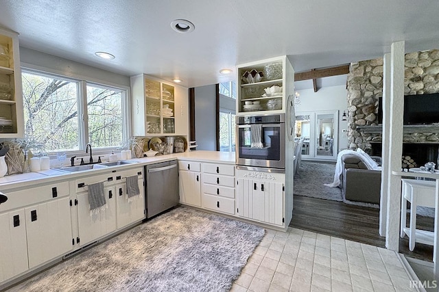 55960 County Road 23, Bristol, IN 46507 - kitchen featuring a sink, appliances with stainless steel finishes, a stone fireplace, and light countertops