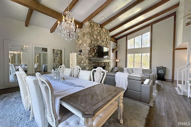 55960 County Road 23, Bristol, IN 46507 - dining room featuring a wood stove, beam ceiling, a notable chandelier, and a fireplace