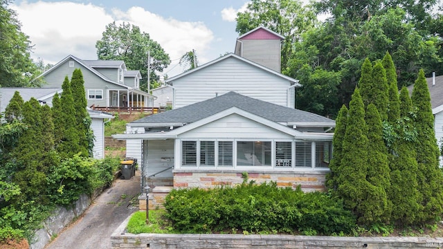 view of front of property featuring a shingled roof and a chimney