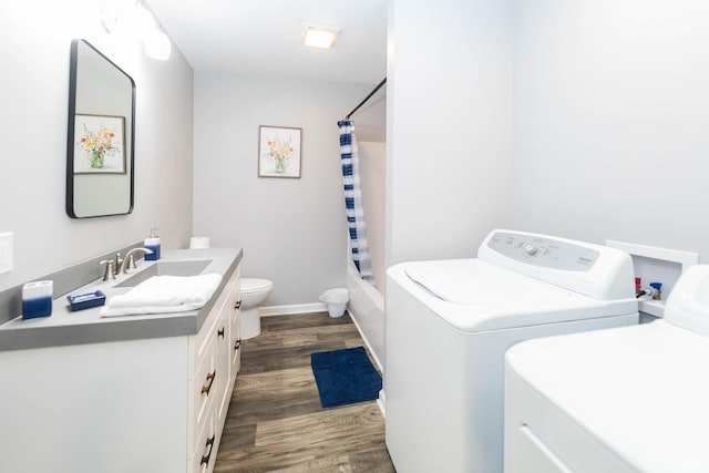 full bath featuring washing machine and clothes dryer, wood finished floors, shower / tub combo, vanity, and toilet